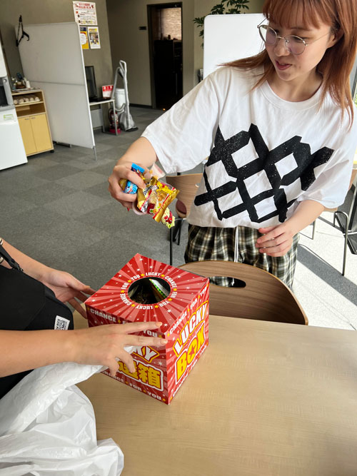 お菓子の摑み取りを楽しむ社員