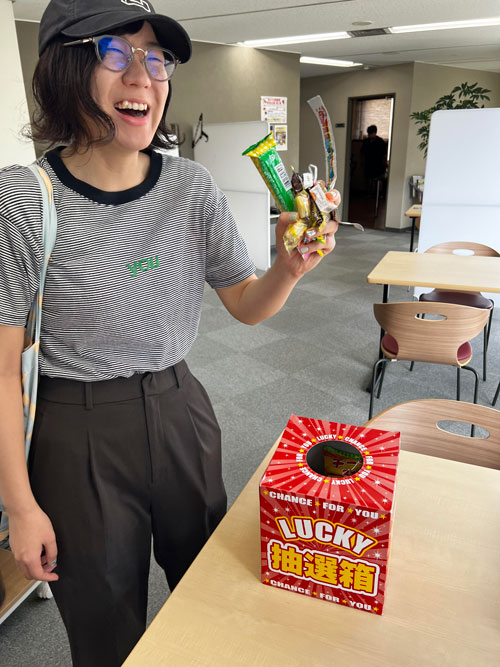 お菓子の摑み取りを楽しむ社員