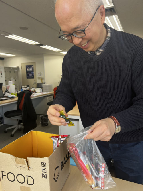 お菓子の摑み取りをする森田社長