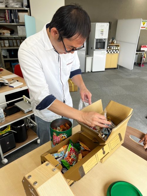 お菓子の摑み取りをする社員