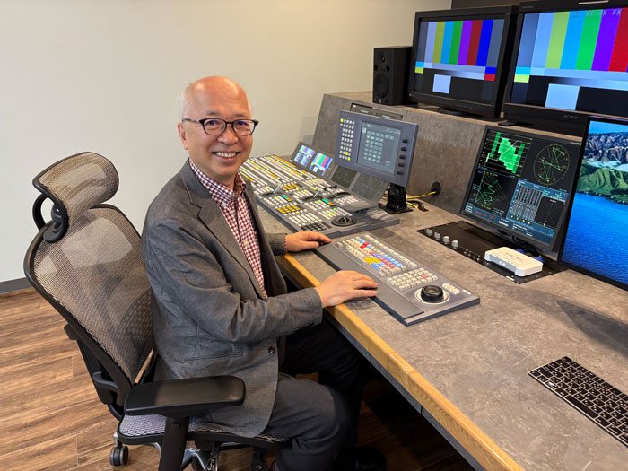 卓の横でインタビューに答える森田社長