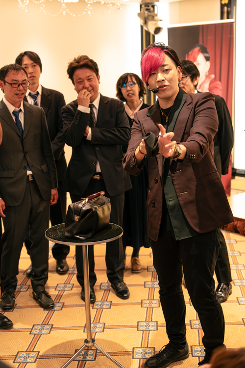 ミタマさんの華麗なマジックに真剣なまなざしで見る社員達