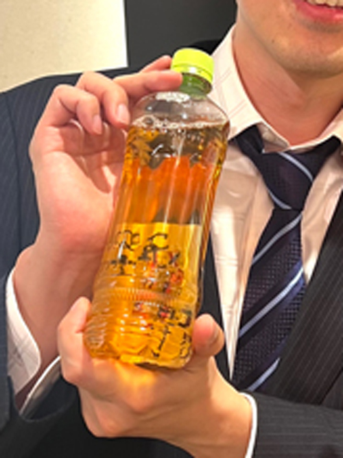 サインをしたトランプが入っているペットボトルの画像