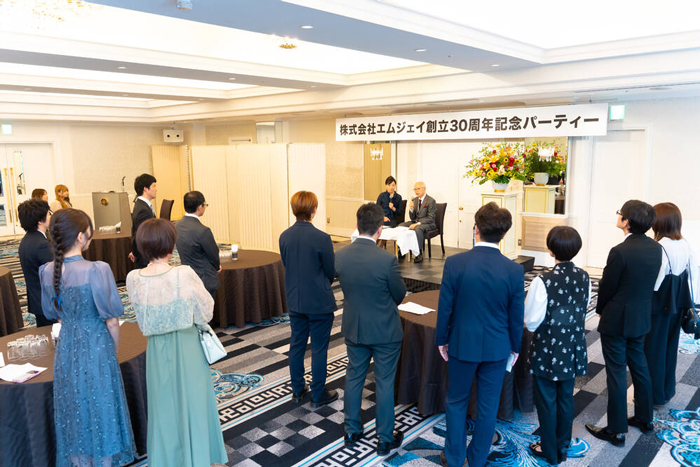 会社の概要について話す森田社長と司会者