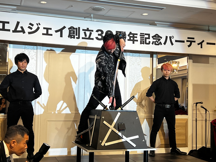 女性の入った小さな箱に剣を刺すミタマさん