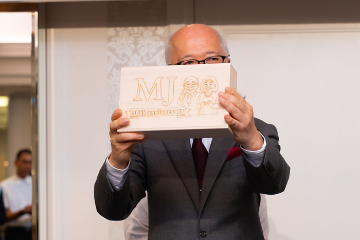 プレゼントされたカステラを見せる社長