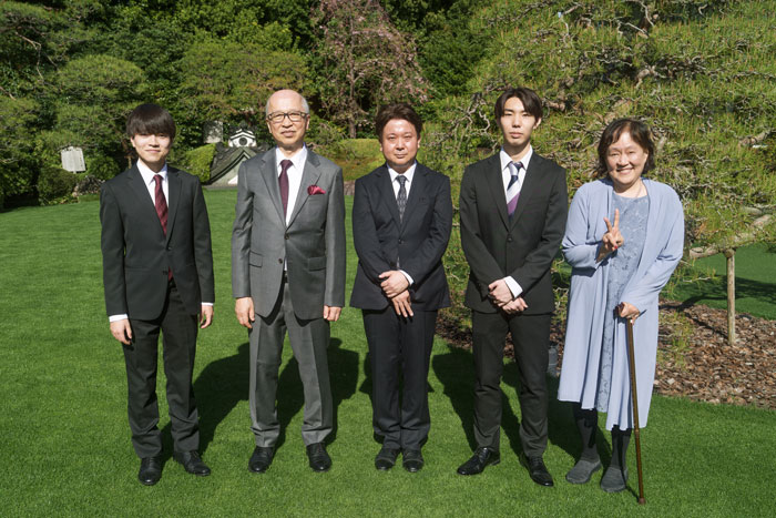 記念写真を撮る新入社員と社長夫妻