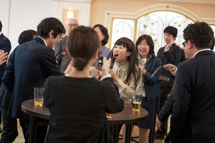 観客を巻き込みながらものまねをするシンディーさんに盛り上がる社員