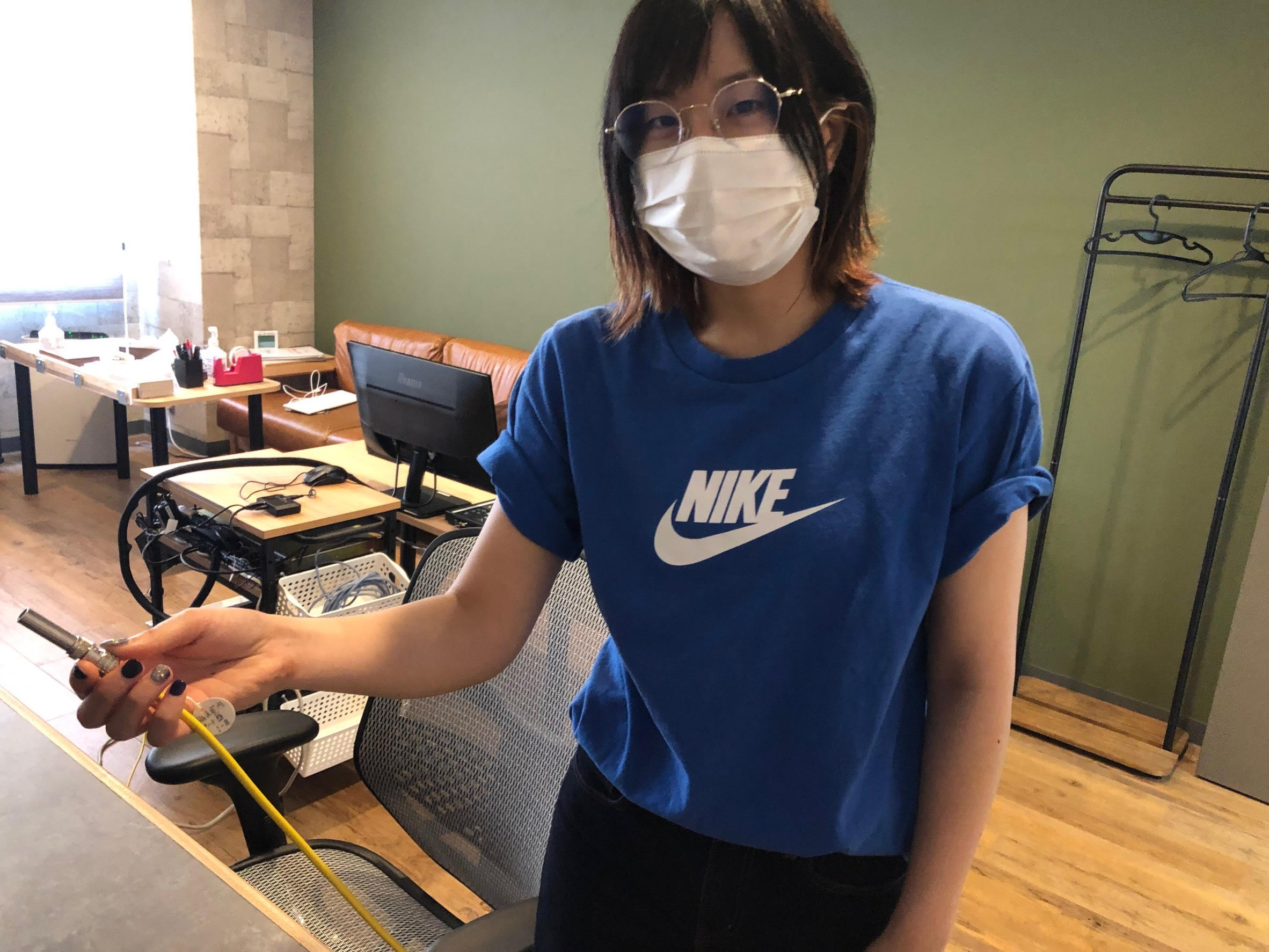 １本のケーブルを持って見せるスタッフ