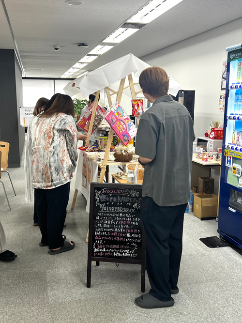 会場に集まって商品を見る従業員